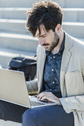 Geschäftsmann arbeitet an einem Laptop - GIOF02887