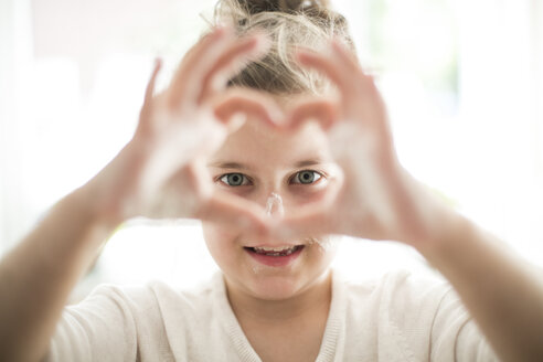 Porträt eines kleinen Mädchens, das mit seinen Fingern ein Herz formt - MOEF00046