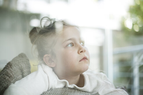 Porträt eines ernsten kleinen Mädchens, das aus dem Fenster schaut - MOEF00058