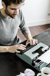 Young man at desk using typewriter - GIOF02891