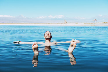 Chile, Atacama-Wüste, glücklicher Mann schwimmt in der Laguna Cejar - GEMF01717