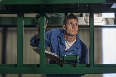 Worker with clipboard in factory stock photo