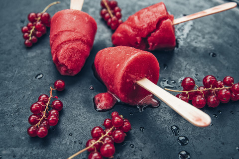 Homemade currant popsicles and red currants on slate stock photo