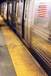 USA, New York City, Bahnsteig einer U-Bahn-Station mit fahrendem U-Bahn-Zug - MAUF01156