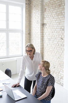 Ältere Geschäftsfrau arbeitet mit jüngerem Kollegen im Büro - RBF05752