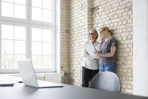 Mature businesswoman working with younger colleague in office stock photo