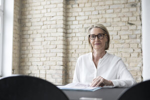 Mature businesswoman working in office, reading documents - RBF05789