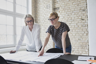 Mature businesswoman working with younger colleague in office - RBF05796