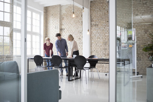 Mature businesswoman working with younger colleagues in office - RBF05807