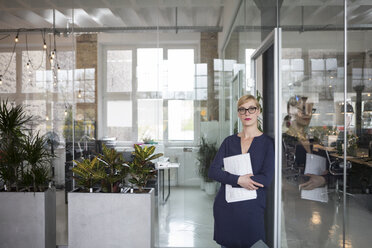 Porträt einer Geschäftsfrau im Büro, die Papiere hält - RBF05825
