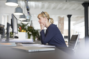 Businesswoman working in office, being stressed out - RBF05833