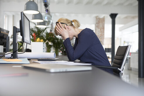 Geschäftsfrau arbeitet im Büro und ist gestresst - RBF05834