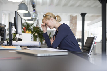 Geschäftsfrau arbeitet im Büro und ist gestresst - RBF05835