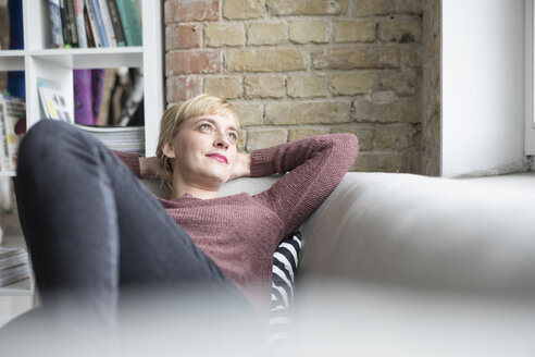 Woman relaxing on couch at home - RBF05840
