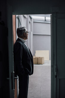Senior businessman standing in door frame - GUSF00002