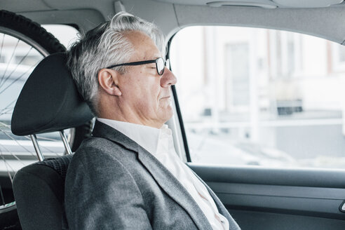Älterer Geschäftsmann sitzt mit geschlossenen Augen im Auto - GUSF00015