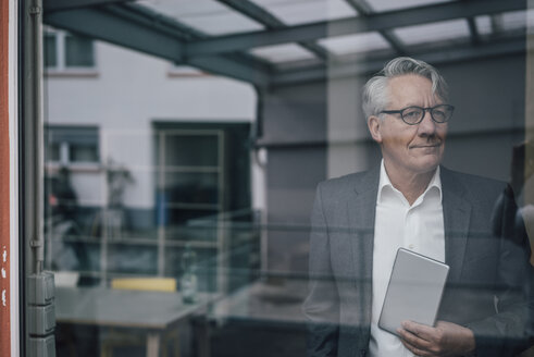 Selbstbewusster älterer Geschäftsmann hinter der Fensterscheibe - GUSF00017