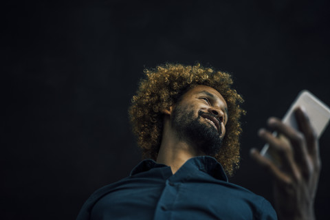 Smiling young man holding cell phone stock photo