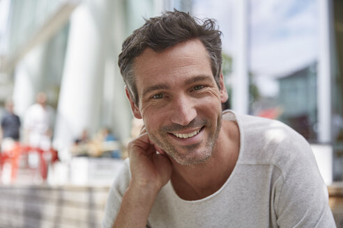 Portrait of smiling man at an outdoor cafe - SUF00216