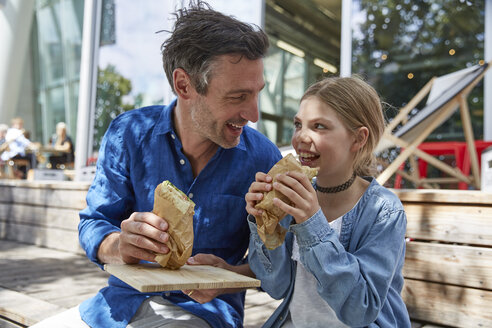 Father and daughter having a snack at an outdoor cafe - SUF00217