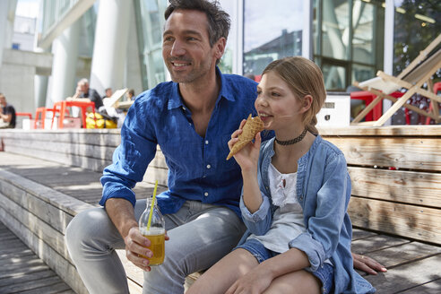 Father with drink and daughter with ice cream cone at an outdoor cafe - SUF00218