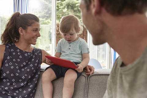 Mother watching little son using tablet at home stock photo