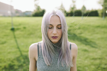 Junge Frau mit rosa, grauen Haaren auf einer Wiese - GIOF02899