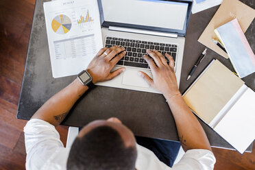 Mann mit Laptop am Schreibtisch im Heimbüro - GIOF02919