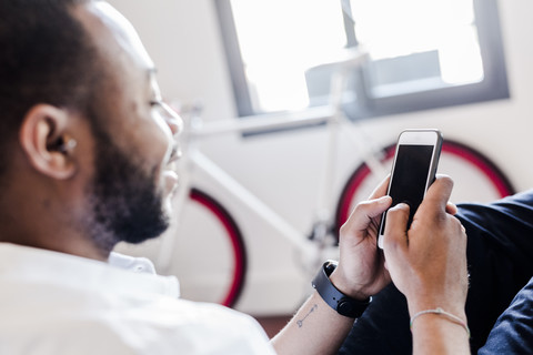 Nahaufnahme eines Mannes, der ein Mobiltelefon benutzt, lizenzfreies Stockfoto