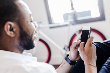 Nahaufnahme eines Mannes, der ein Mobiltelefon benutzt - GIOF02926