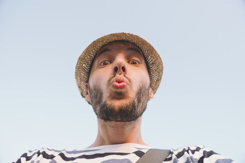 Man with straw hat kissing to the camera - GEMF01740