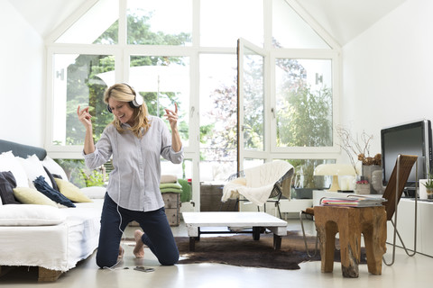 Excited woman at home listening to music stock photo