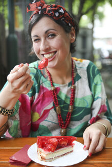 Woman eating strawberry cake in street cafe - RTBF00991