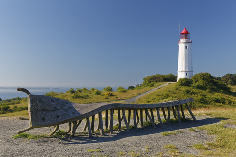 Deutschland, Mecklenburg-Vorpommern, Hiddensee, Dornbusch-Leuchtturm auf dem Schluckswiek, mit alter gedrechselter Holzbank im Vordergrund, lizenzfreies Stockfoto