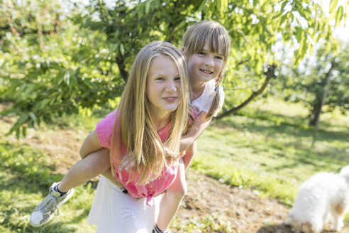 Zwei Schwestern haben Spaß im Garten - SHKF00759