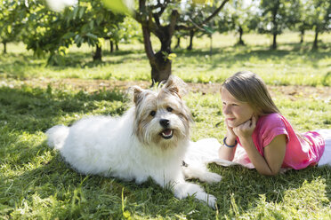 Mädchen liegend mit Hund auf Wiese - SHKF00765