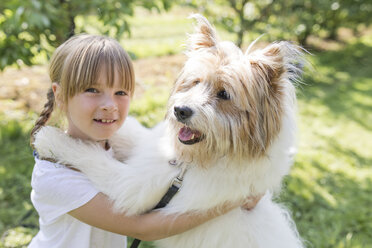 Mädchen spielt mit Hund auf Wiese - SHKF00767