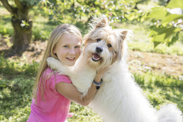 Mädchen spielt mit Hund auf Wiese - SHKF00768