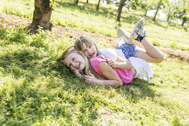 Two happy sisters playing in meadow - SHKF00776