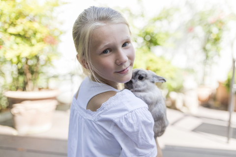 Porträt eines Mädchens mit Kaninchen im Freien, lizenzfreies Stockfoto