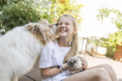 Glückliches Mädchen mit Kaninchen und Hund im Freien - SHKF00787