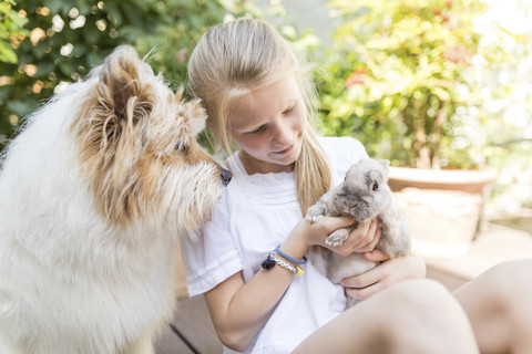 Mädchen mit Kaninchen und Hund im Freien, lizenzfreies Stockfoto