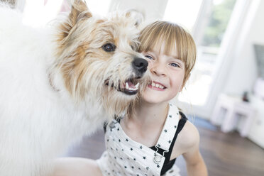 Glückliches Mädchen mit Hund zu Hause - SHKF00789