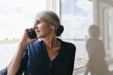 Geschäftsfrau am Telefon am Fenster - KNSF01763
