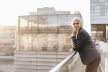 Portrait of confident businesswoman standing on bridge - KNSF01786