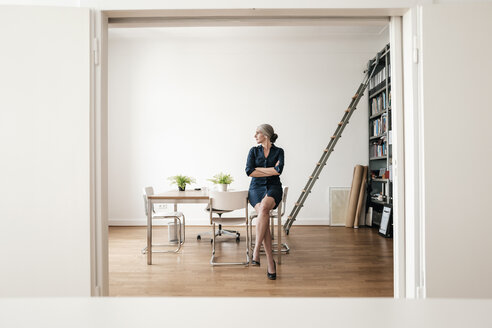 Geschäftsfrau sitzt in einem modernen Büro - KNSF01789