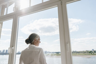 Geschäftsfrau schaut aus dem Fenster - KNSF01792