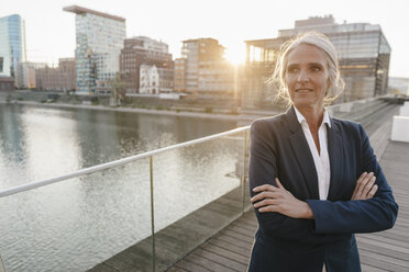 Confident businesswoman standing on bridge - KNSF01798