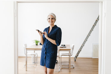 Businesswoman sitting on windiwsill - KNSF01811