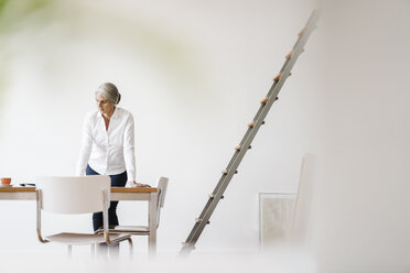 Businesswoman standing in modern office - KNSF01826